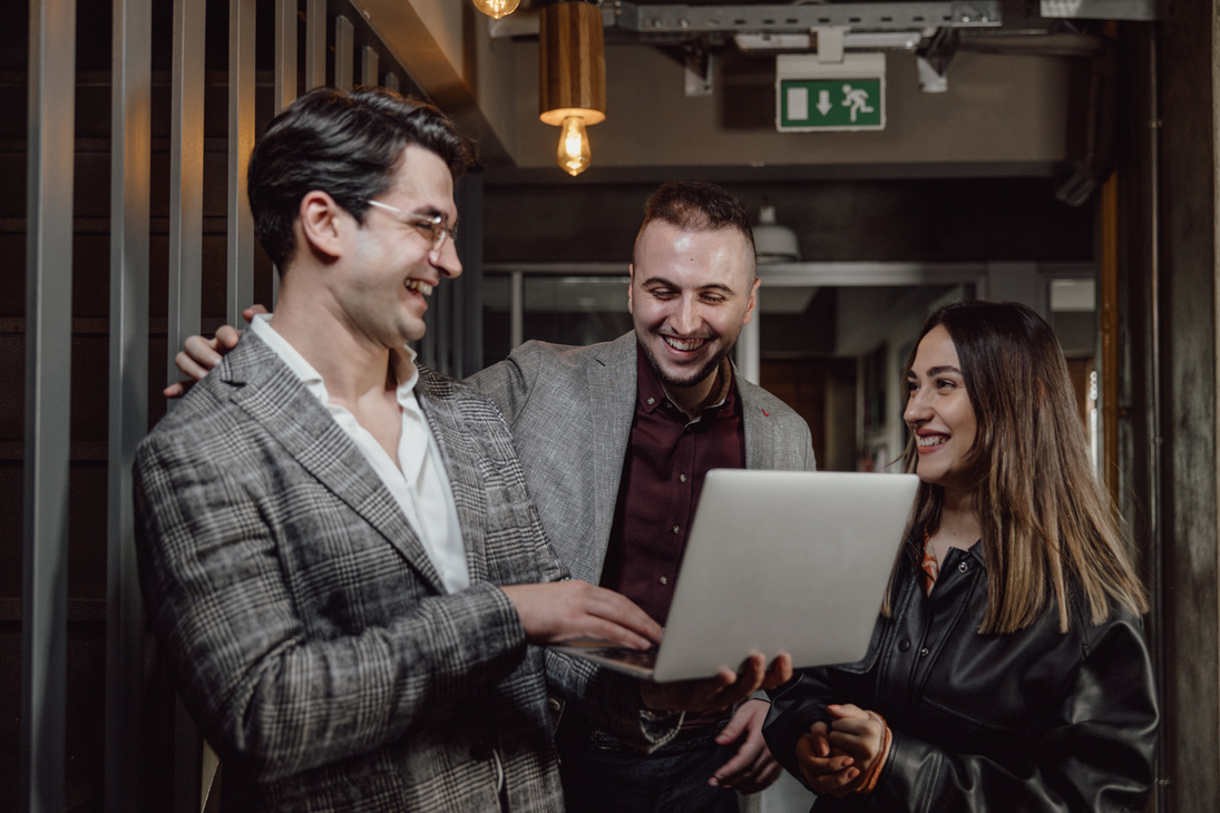 Young People Laughing Together in front of a Laptop 